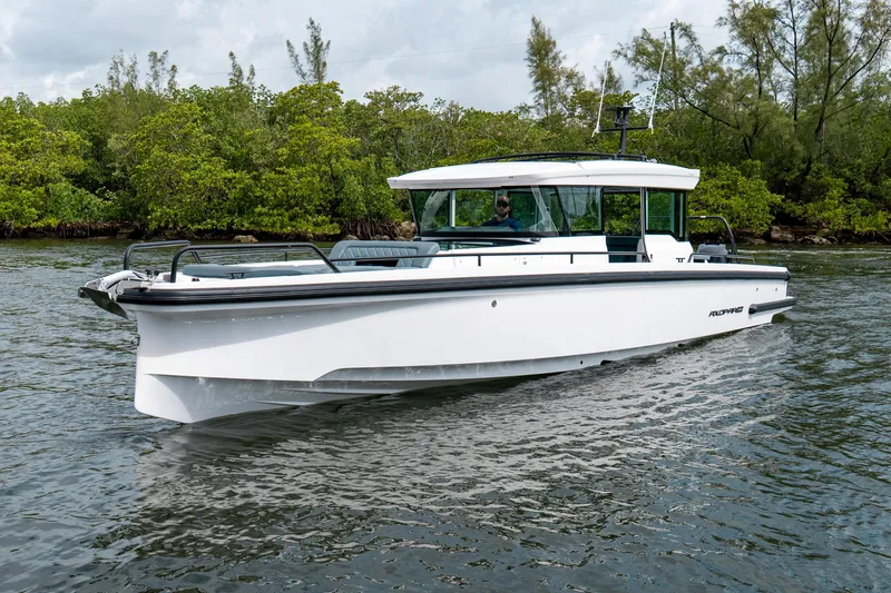 Slide: The Image of 2022 Axopar 37 XC Cross Cabin boat cruising on a calm waterway. - 9