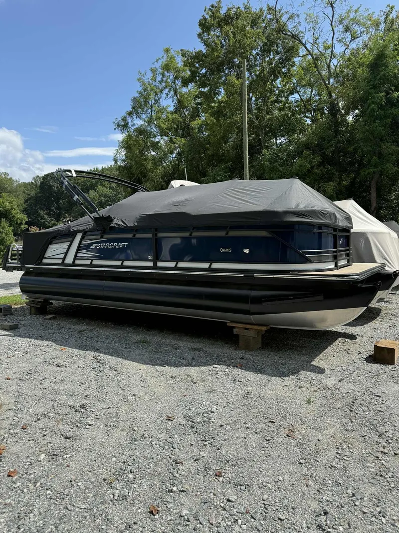 The Image of 2025 Starcraft SLS 3 Q DH pontoon boat on gravel lot. - 1