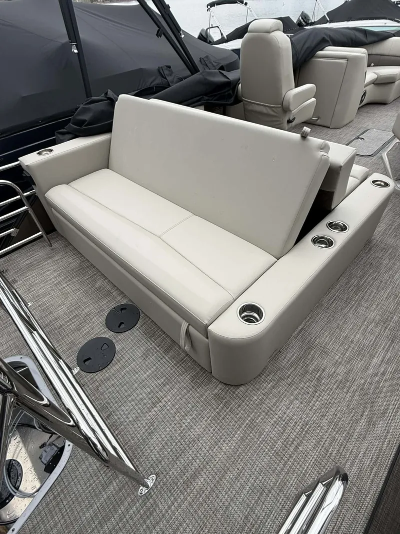 Slide: The Image of Interior of 2026 Manitou 23 Encore SLVPII with beige sofa and cup holders. - 26