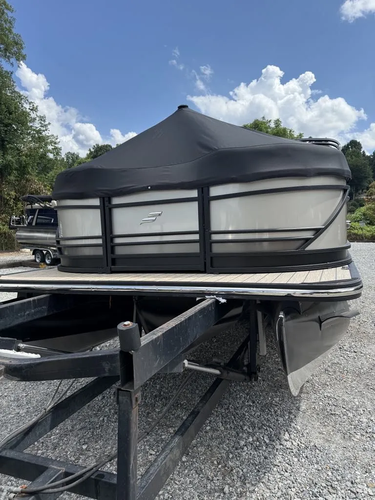 Slide: The Image of 2025 Starcraft SLS-3 pontoon boat on trailer, covered, sunny day. - 12