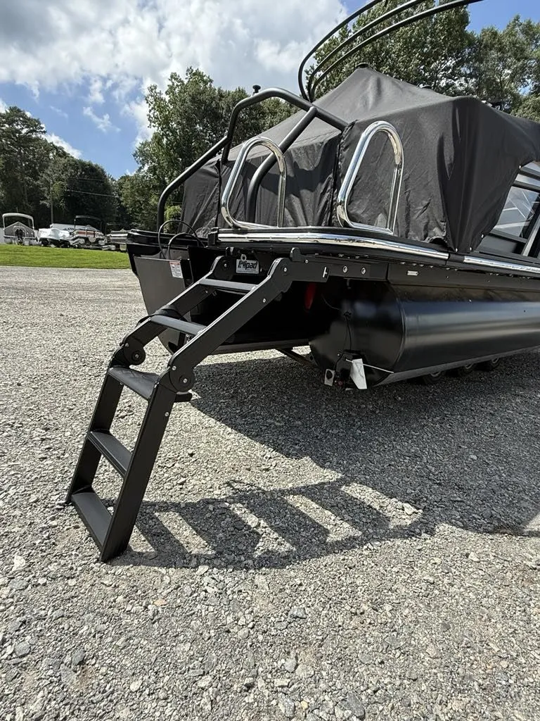 Slide: The Image of Starcraft SLS-3 2025 pontoon boat with ladder on gravel surface. - 16