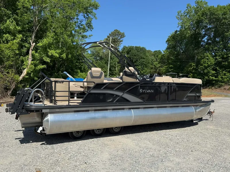 Slide: The Image of 2025 Sylvan L-3 Party Fish pontoon boat parked on gravel surface. - 18