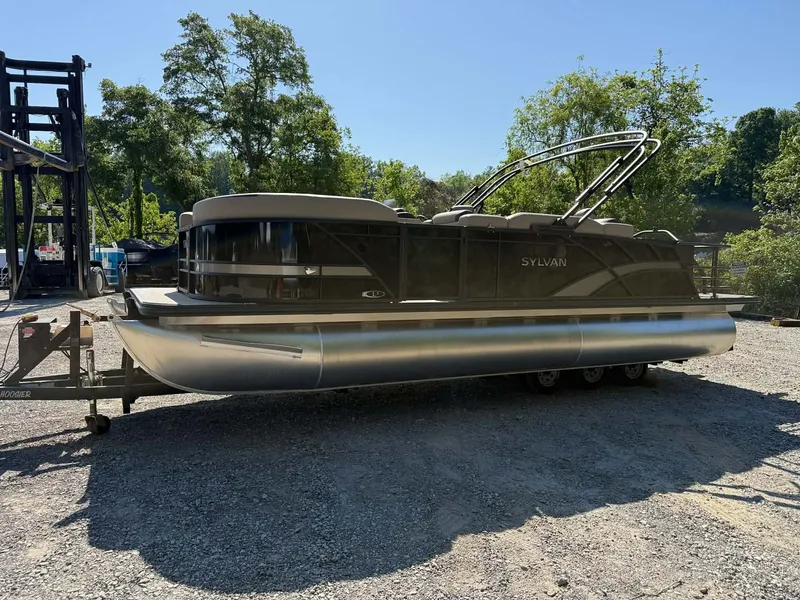 Slide: The Image of 2025 Sylvan L-3 Party Fish pontoon boat on trailer outdoors. - 27
