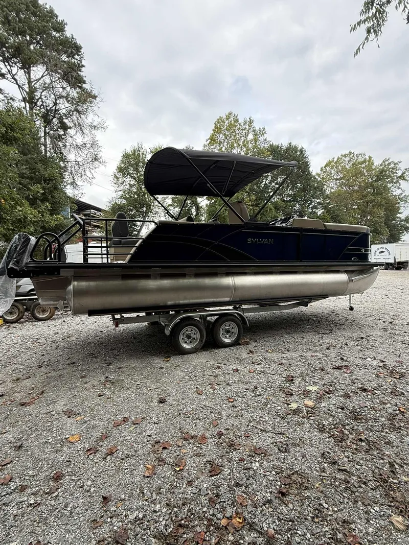 Slide: The Image of 2026 Sylvan L-3 DLZ pontoon boat on trailer outdoors. - 3