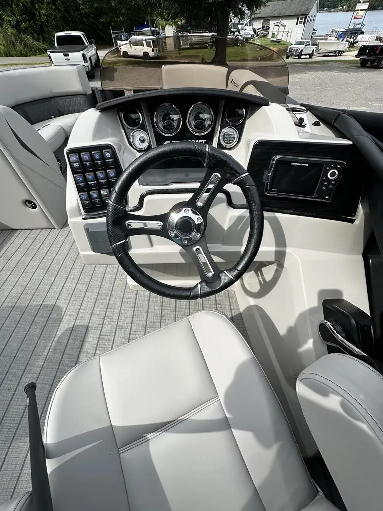 Slide: The Image of 2024 Starcraft CX 23 Q DH boat dashboard with steering wheel and controls. - 3