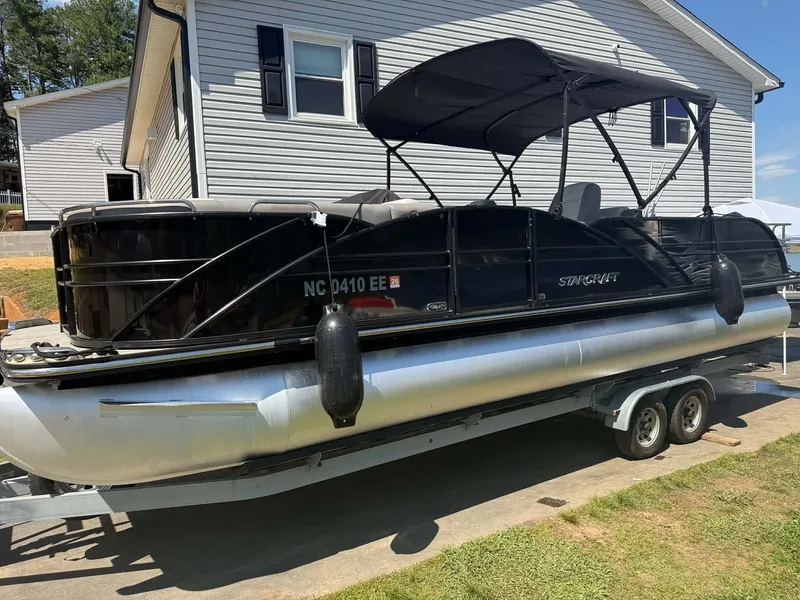 Slide: The Image of 2017 Starcraft MX 25 pontoon boat on trailer in front of house. - 10