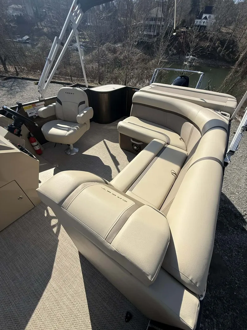 Slide: The Image of Interior of a 2024 Crest Classic LX 200 pontoon boat with beige seating. - 15