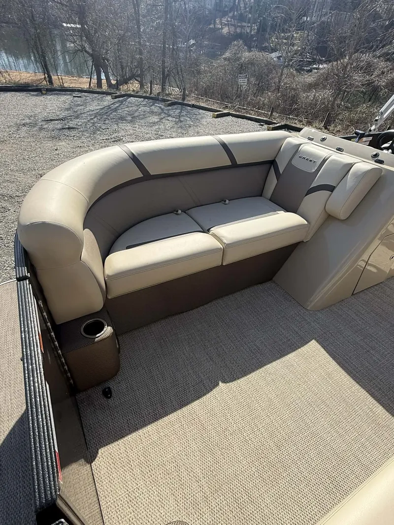 Slide: The Image of 2024 Crest Classic LX 200 pontoon boat with beige seating area. - 5