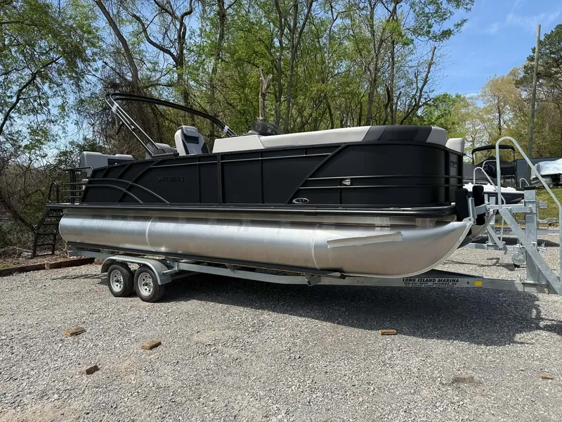 The Image of 2026 Sylvan L-3 RLZ pontoon boat on trailer outdoors. - 1