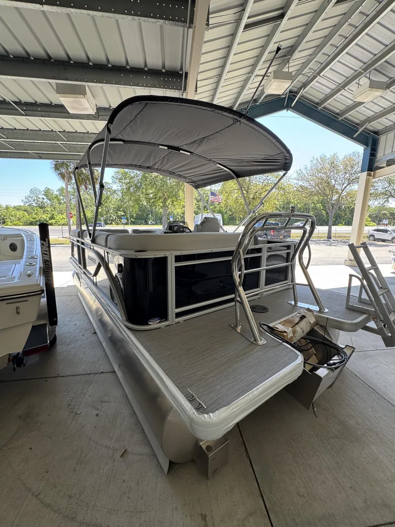 Slide: The Image of Sweetwater SW2086CSE 2026 pontoon boat under covered area. - 17