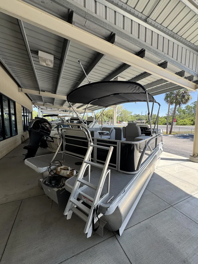 Slide: The Image of 2026 Sweetwater SW2086CSE pontoon boat parked under a canopy. - 6