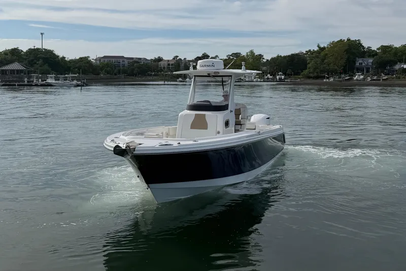 Slide: The Image of Edgewater 262CC 2021 boat cruising on calm waters near a scenic shoreline. - 15