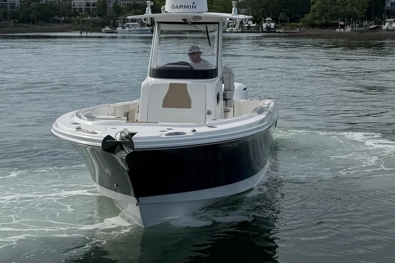 Slide: The Image of 2021 Edgewater 262CC boat cruising on calm waters with a Garmin system. - 16