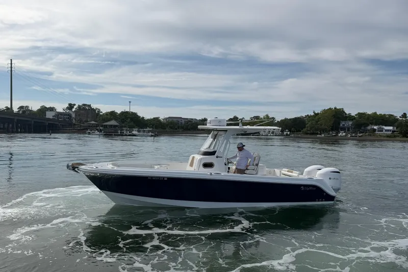 Slide: The Image of 2021 Edgewater 262CC boat cruising on calm waters under a cloudy sky. - 18