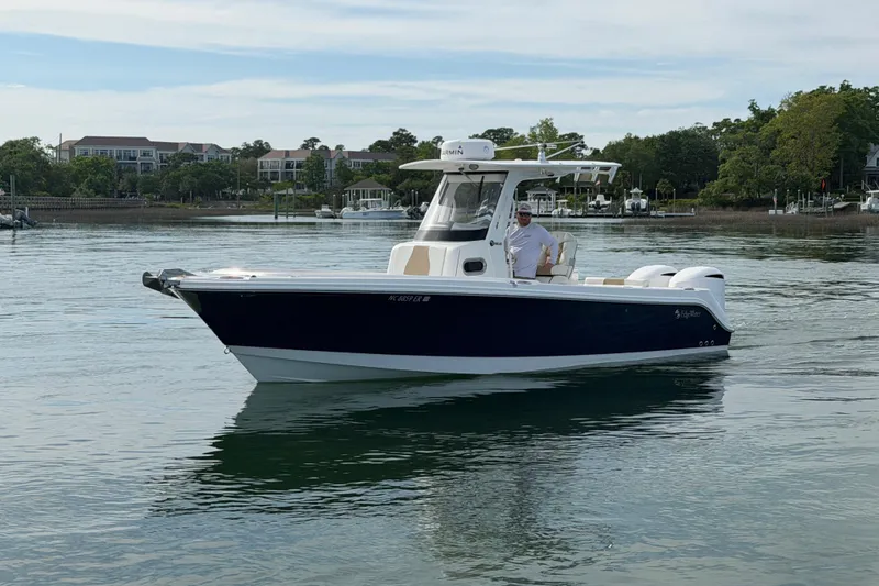 Slide: The Image of 2021 Edgewater 262CC boat cruising on calm water near a residential area. - 20