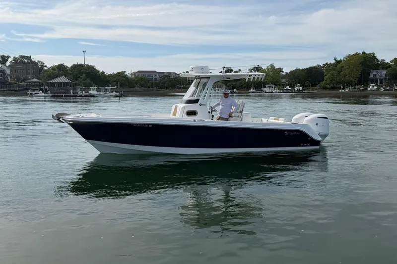 Slide: The Image of 2021 Edgewater 262CC boat on calm water with scenic background. - 21