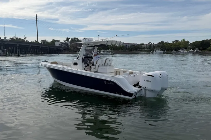 Slide: The Image of 2021 Edgewater 262CC boat cruising on calm water with Yamaha engines. - 25