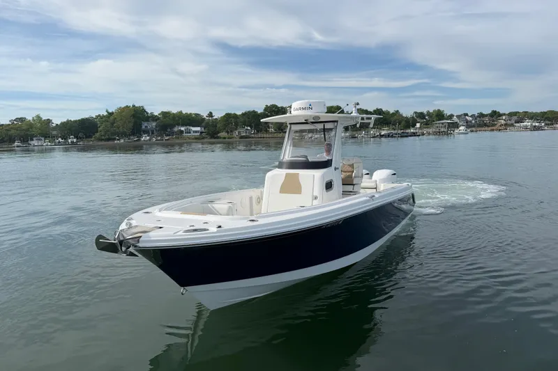 Slide: The Image of 2021 Edgewater 262CC boat cruising on calm waters near a scenic shoreline. - 26
