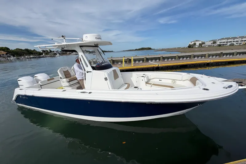 Slide: The Image of 2021 Edgewater 262CC boat docked on calm water with clear sky background. - 27