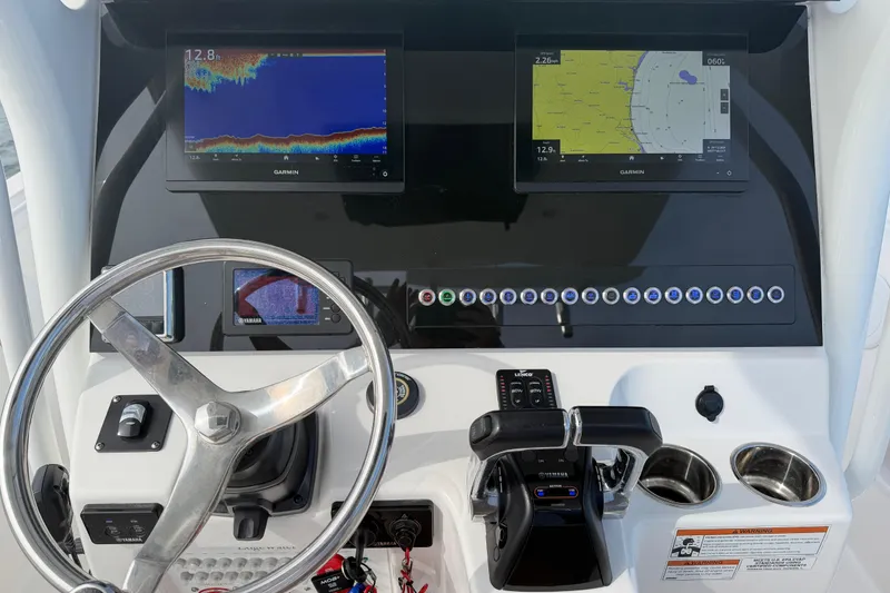 Slide: The Image of Edgewater 262CC 2021 boat dashboard with Garmin displays and steering wheel. - 45