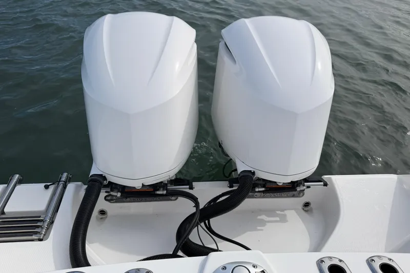 Slide: The Image of Twin outboard engines on a 2021 Edgewater 262CC boat, floating on water. - 49