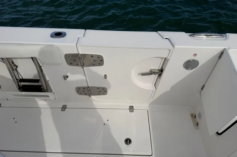 Slide: The Image of 2021 Edgewater 262CC boat deck with storage compartments and water access. - 50