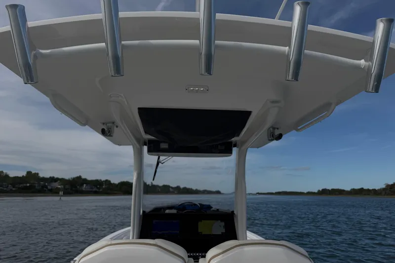 Slide: The Image of 2021 Edgewater 262CC boat console with rod holders on a calm water backdrop. - 55