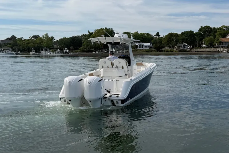 Slide: The Image of Edgewater 262CC 2021 boat cruising on calm waters near a scenic shoreline. - 6