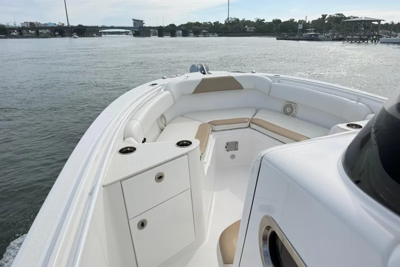 Slide: The Image of 2021 Edgewater 262CC boat interior with seating and storage, on calm water. - 61