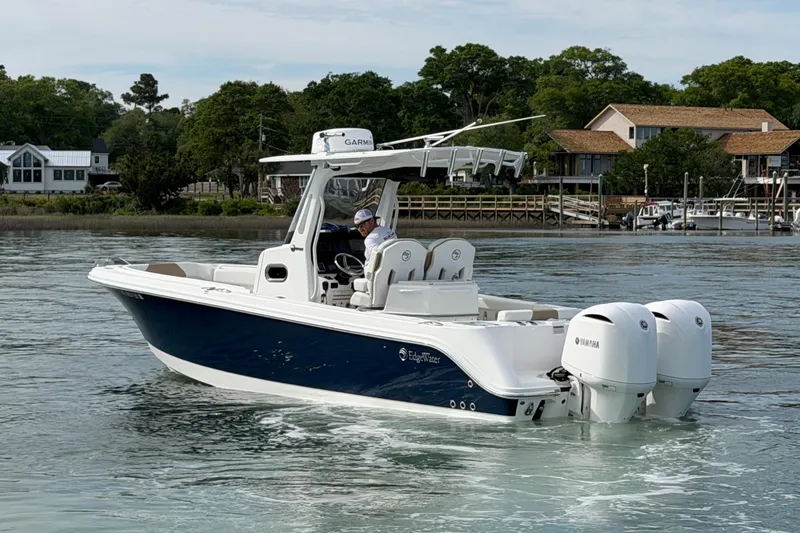 Slide: The Image of 2021 Edgewater 262CC boat with dual Yamaha engines on a calm waterway. - 7