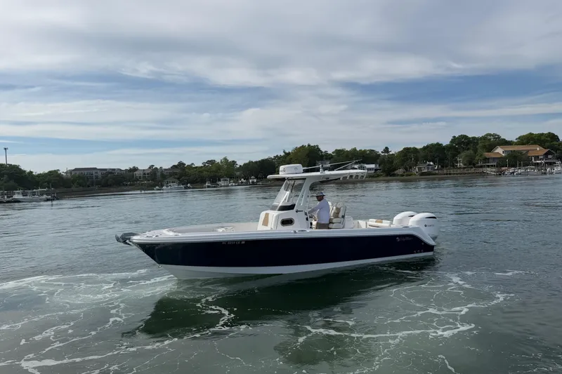 Slide: The Image of 2021 Edgewater 262CC boat cruising on calm waters near a scenic shoreline. - 8