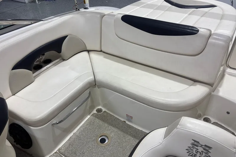 Slide: The Image of 2009 Chaparral 236 SSX boat interior with white cushioned seating and cup holders. - 11