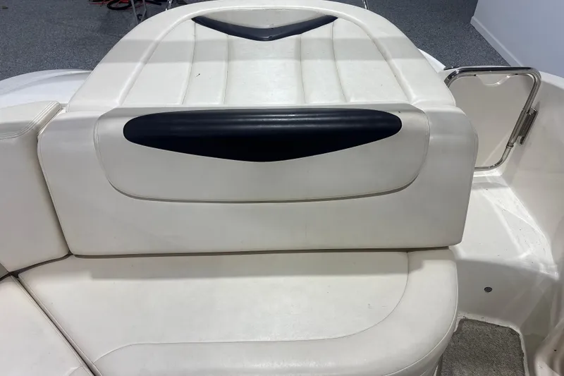 Slide: The Image of 2009 Chaparral 236 SSX boat interior seating with white upholstery and black accents. - 12
