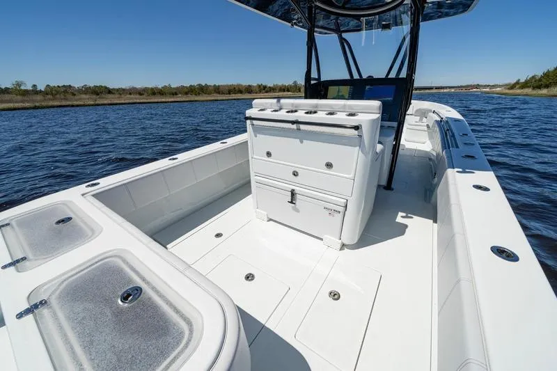 Slide: The Image of 2022 Contender 32 ST boat interior on water, featuring spacious deck and storage compartments. - 16