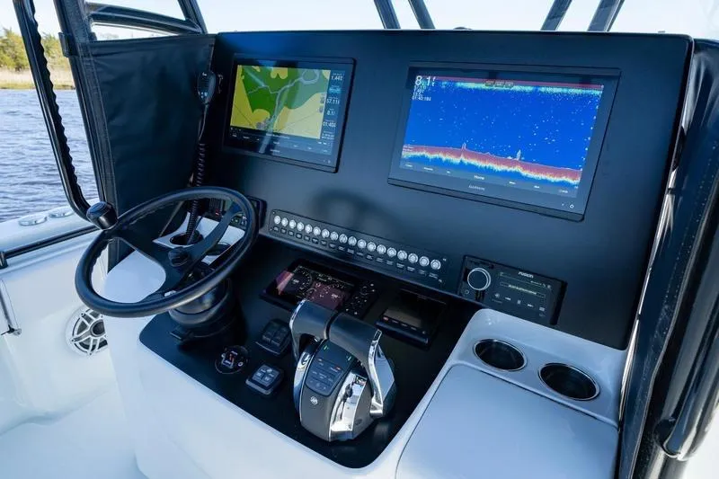 Slide: The Image of 2022 Contender 32 ST boat dashboard with navigation screens and controls. - 17