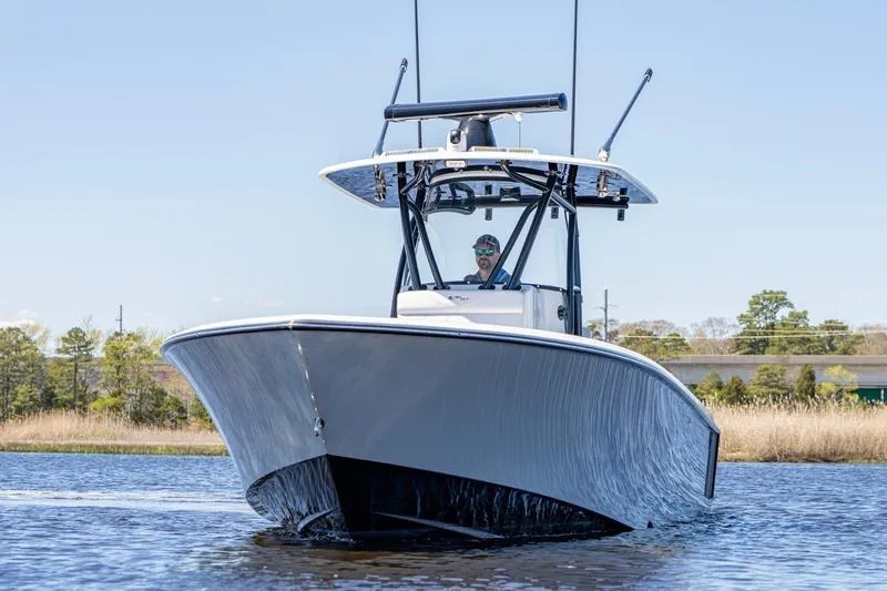 Slide: The Image of 2022 Contender 32 ST boat cruising on a calm waterway under clear skies. - 8