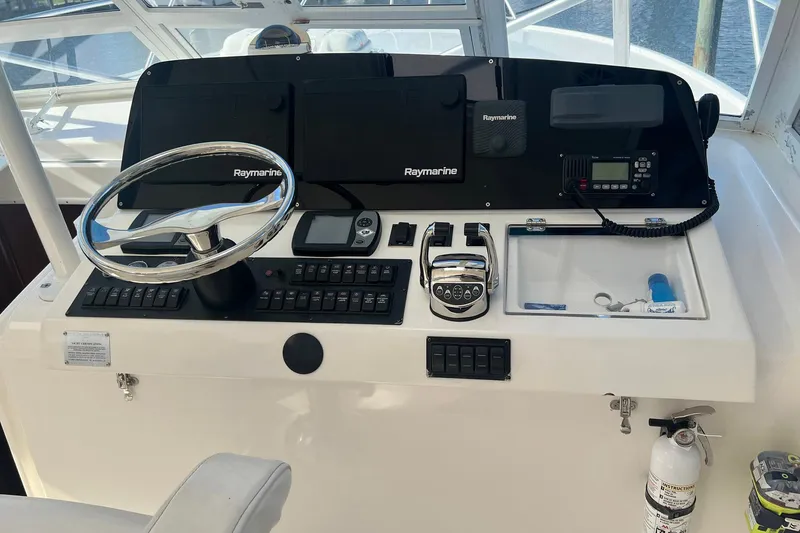 Slide: The Image of 2007 Luhrs 41 Hardtop helm with Raymarine electronics and steering wheel. - 18