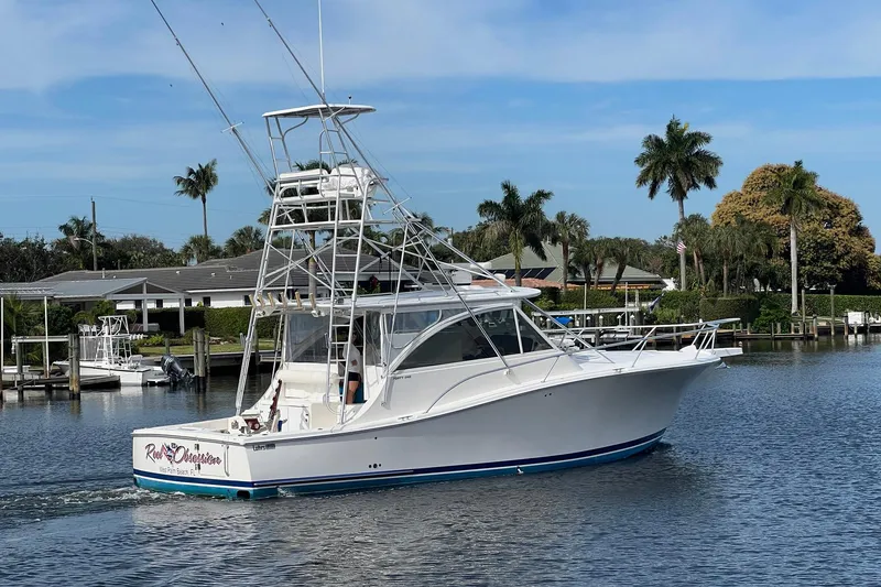 Slide: The Image of 2007 Luhrs 41 Hardtop yacht cruising on a sunny day near palm trees. - 2