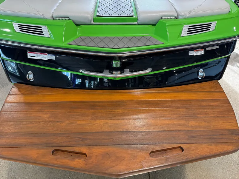 Slide: The Image of Rear view of a 2015 MasterCraft X10 boat with green accents. - 7