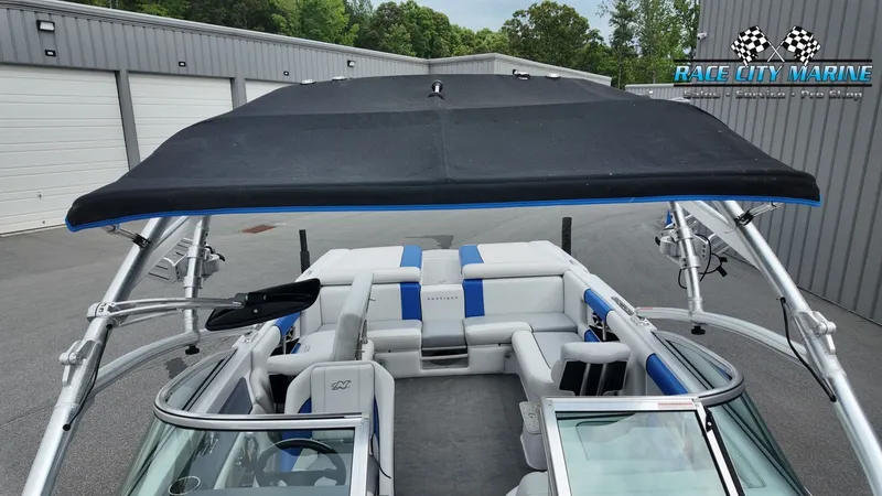 Slide: The Image of 2007 Correct Craft 236TE boat with bimini top and blue accents. - 35
