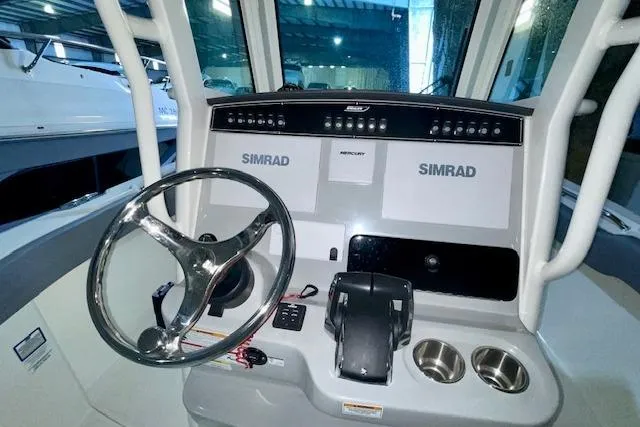 Slide: The Image of 2024 Boston Whaler 280 Outrage helm with Simrad electronics and steering wheel. - 5