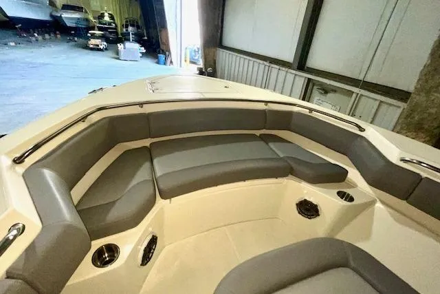 Slide: The Image of 2024 Boston Whaler 280 Outrage boat interior with cushioned seating in a storage facility. - 7