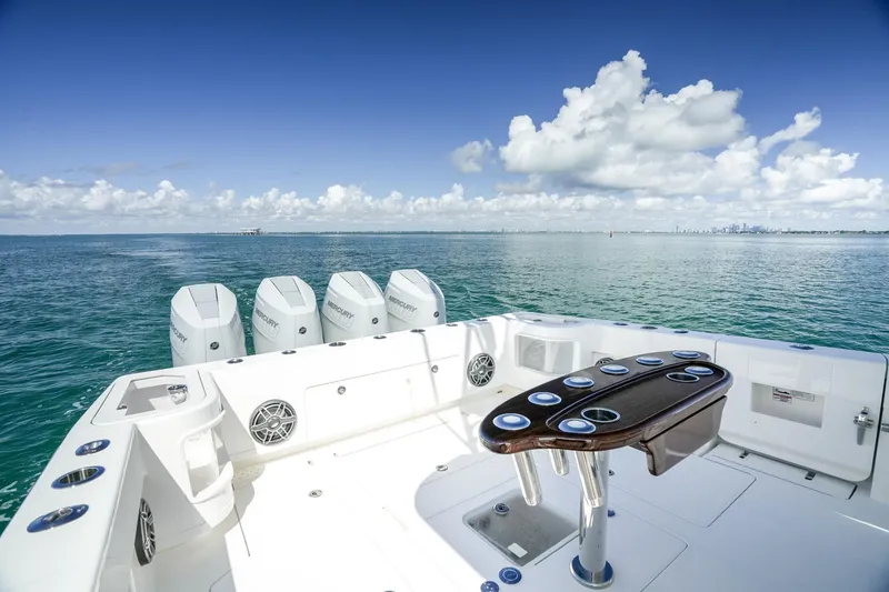 Slide: The Image of 2024 SeaVee 400Z boat with multiple outboard engines on open water under a clear sky. - 13