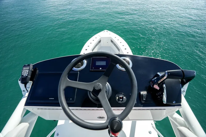 Slide: The Image of 2024 SeaVee 400Z boat helm with steering wheel and controls on open water. - 17