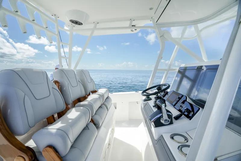 Slide: The Image of 2024 SeaVee 400Z boat interior with modern helm and seating, overlooking the ocean. - 2
