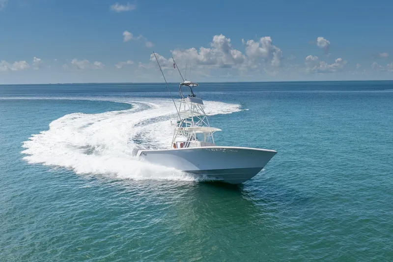 Slide: The Image of 2024 SeaVee 400Z boat cruising on open ocean under clear blue sky. - 25