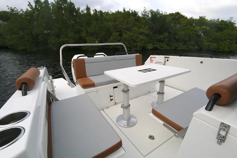 Slide: The Image of 2022 Beneteau Flyer 9 SPACEdeck boat interior with seating and table, surrounded by water and trees. - 12
