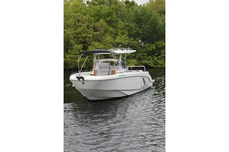 Slide: The Image of 2022 Beneteau Flyer 9 SPACEdeck boat on calm water, surrounded by lush greenery. - 18