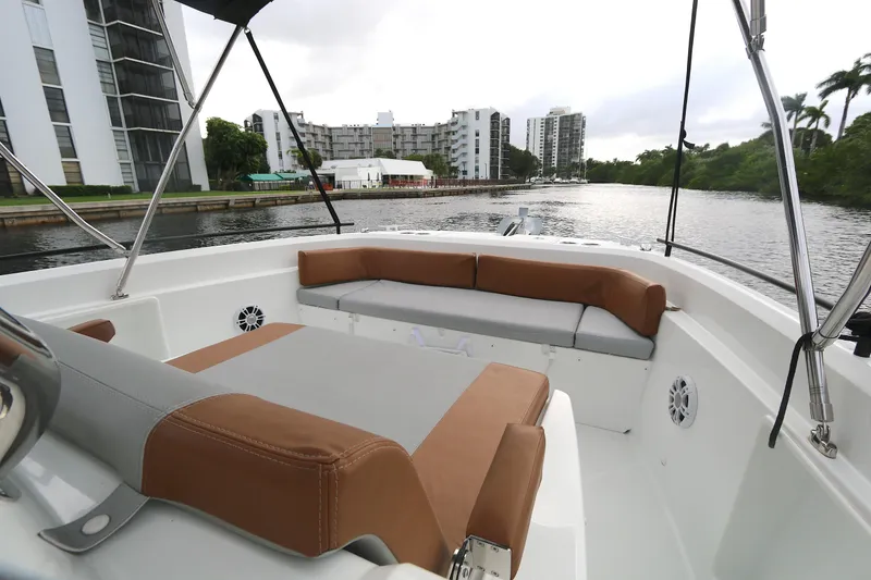 Slide: The Image of 2022 Beneteau Flyer 9 SPACEdeck boat interior with cushioned seating, dockside view. - 8