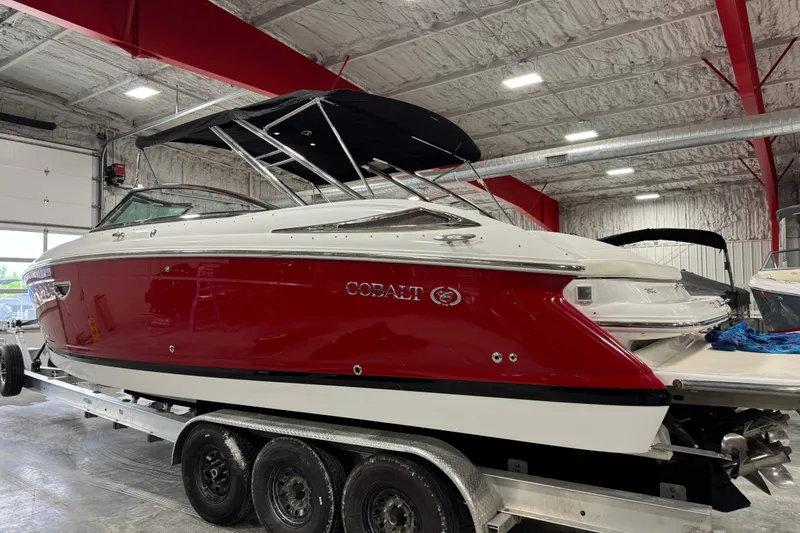Slide: The Image of 2007 Cobalt 302 boat with red and white exterior in a storage facility. - 3
